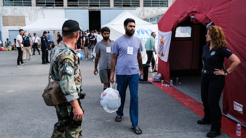 Shipwreck survivors await transfer to a refugee camp near Athens