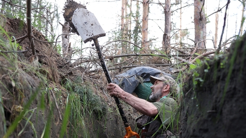 A Ukrainian soldier digs a trench at the front line near the town of Kreminna, Lugansk region