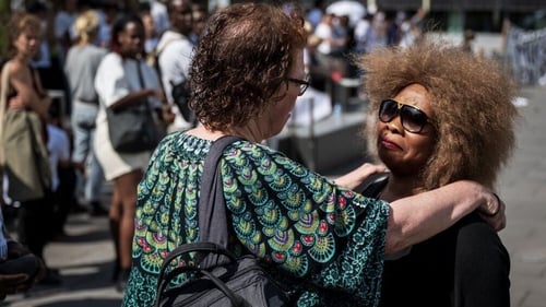 Bridget Efe (R), the wife of Mike Ben Peter, is comforted after the verdict