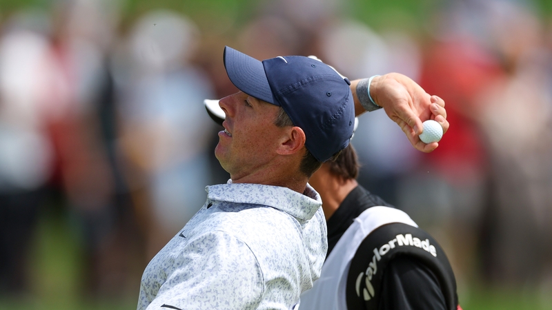 Rory McIlroy of Northern Ireland tosses his golf ball to fans after making a hole-in-one on the eighth