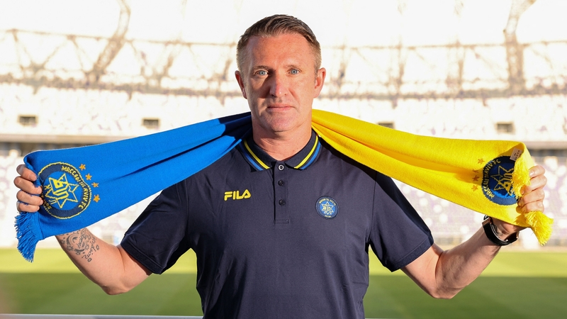 Robbie Keane poses with a Maccabi Tel Aviv scarf at his unveiling