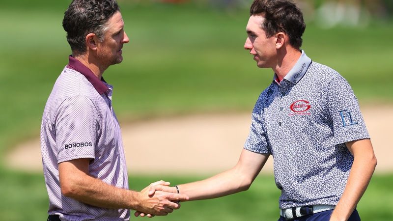 Justin Rose and Tom McKibbin shake hands after finishing their round on the ninth green
