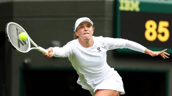 Iga Swiatek stretches to make a forehand return in her win over Zhu Lin