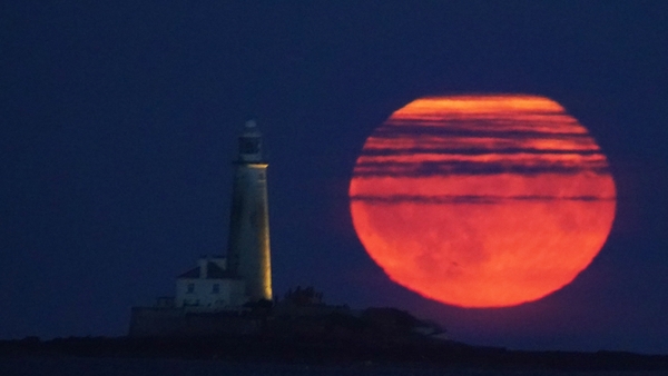 The Full Buck supermoon rises over St Mary's Lighthouse in Whitley Bay on the northeast coast of England
