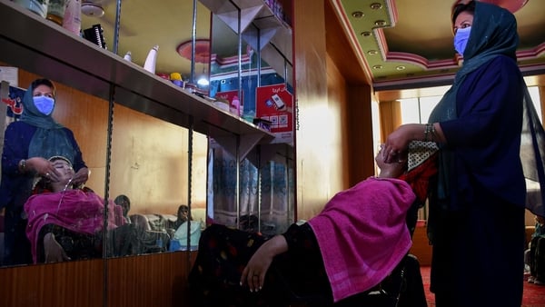 An Afghan beautician attends a customer at a beauty salon in Mazar-i-Sharif