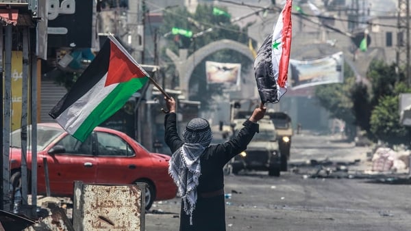 A man confronts an Israeli military vehicle in Jenin