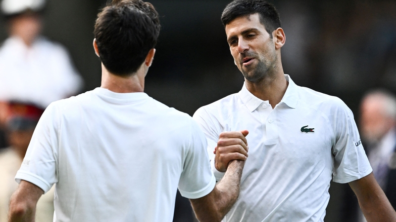 Novak Djokovic (R) shakes hands with Jordan Thompson