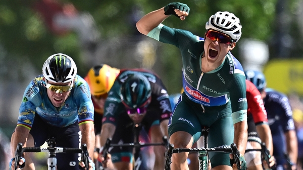 Jasper Philipsen punches the air after crossing the finish line in Bordeaux