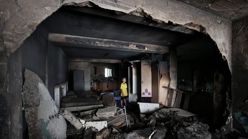 A boy checks the damage inside a house in the occupied West Bank Jenin refugee camp