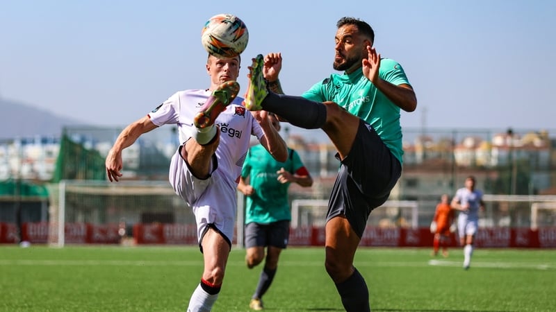Dundalk's Daniel Kelly (L) competes for the ball with Joseph Chipolina