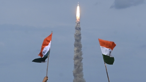 People wave Indian flags as an Indian Space Research Organisation rocket carrying the Chandrayaan-3 spacecraft lifts off from the Satish Dhawan Space Centre in Sriharikota