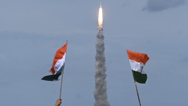 People wave Indian flags as an Indian Space Research Organisation rocket carrying the Chandrayaan-3 spacecraft lifts off from the Satish Dhawan Space Centre in Sriharikota
