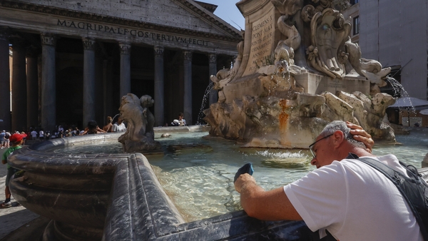 A tourist refreshes at a fountain in front of the Pantheon in Rome, Italy