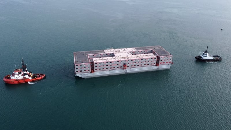 The Bibby Stockholm accommodation barge is manoeuvred into the dock at Portland, Dorset, England