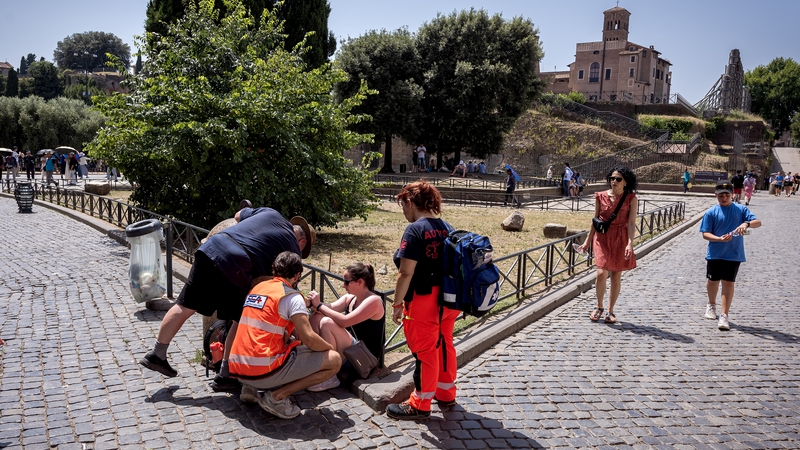 Health workers attend to a tourist struck ill by high temperatures in Rome yesterday