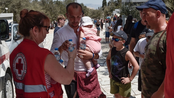 A member of the Red Cross distributes water to visitors at the Acropolis in Athens