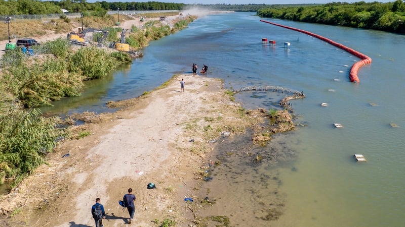 Migrants attempt to cross the Rio Grande river into the US at Eagle Pass, Texas