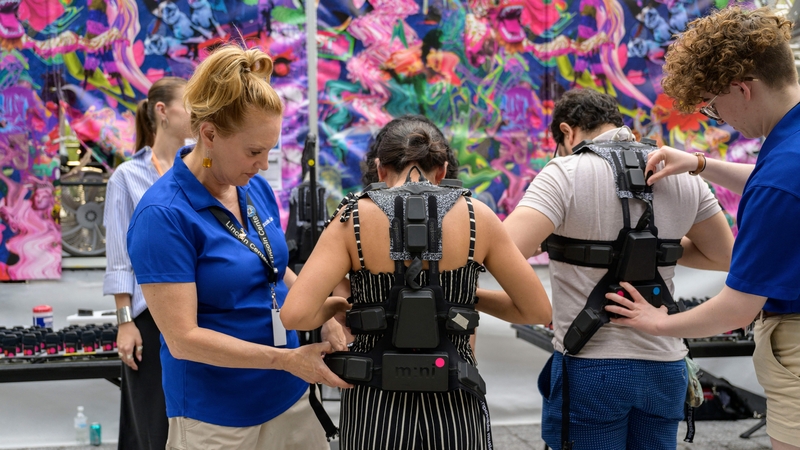 Concertgoers get fitted for haptic suits created for the deaf by Music: Not Impossible, during an outdoor concert at Lincoln Center