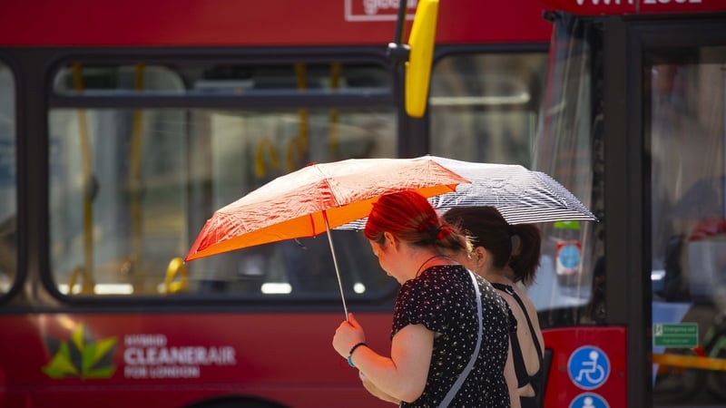 Women use umbrellas to shelter from the sun during last year's heatwave in London