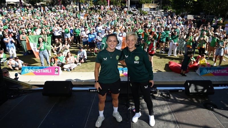 Katie McCabe and Vera Pauw pose in front of a thronged FIFA Fan Festival at South Bank Parklands in Brisbane