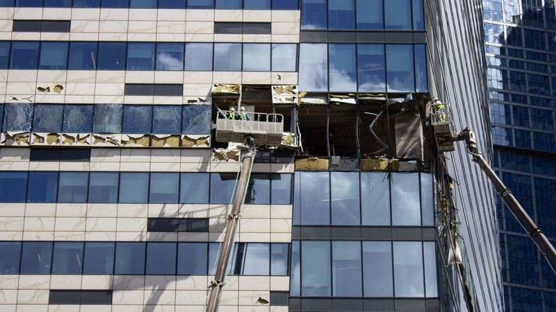 Workers use cranes to clean up the debris at the Moscow International Business Centre