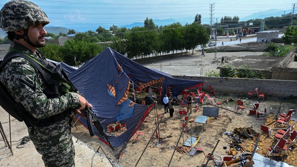 A security personnel stands guard next to the site of the blast in Bajaur district of Khyber-Pakhtunkhwa province