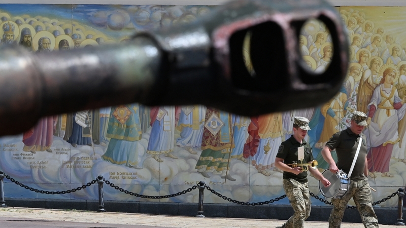 Ukrainian servicemen musicians walk past a tank during an open-air exhibition of destroyed Russian military vehicles at Mykhaylo Square in Kyiv