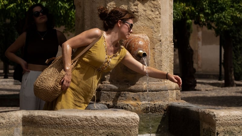 A woman cools off in a fountain in Cordoba, southern Spain