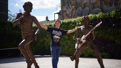 Kian Hunter from Dartford, poses next to "The Glimmer Twins", a statue of Rolling Stones Mick Jagger and Keith Richards created by sculptor Amy Goodman