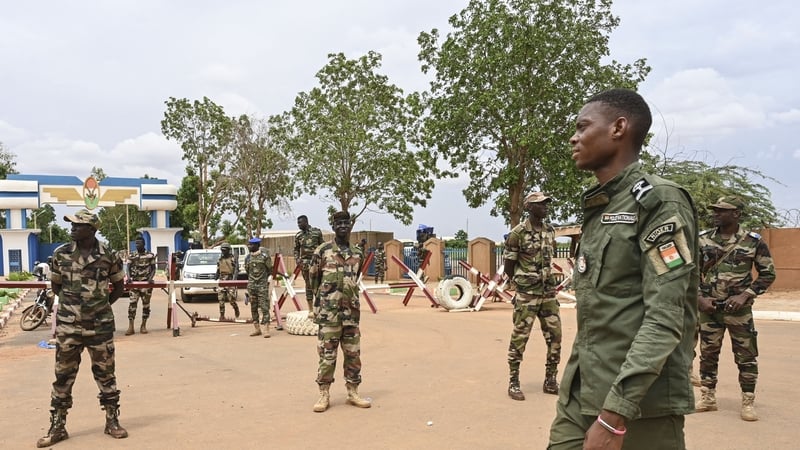 Nigerien soldiers stand guard as supporters of Niger's coup leaders gather for a demonstration in Niamey near a French airbase