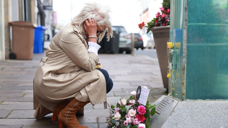 Caroline Martin, sister of Esther Gibson who died in the Omagh bombing, lays flowers at the site of the attack today