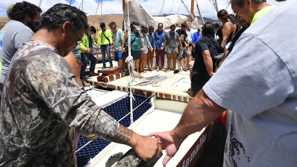 Maalaea Harbor: Members of the Hikianalia Canoe Club commemorate the dead as they prepare to distribute supplies