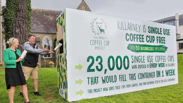 Alice Thompson and Alan Oliver handing in single-use coffee cups into the box in Killarney town centre