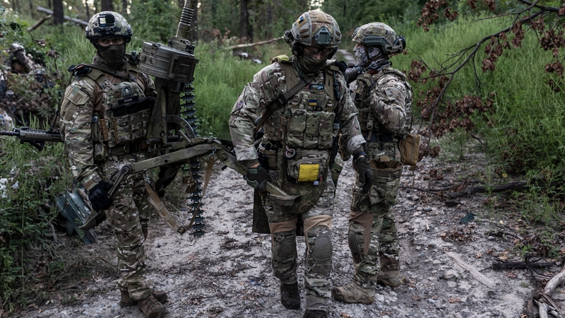 Ukrainian soldiers walk with a grenade launcher in a forest in the direction of Avdivka, Donetsk Oblast, Ukraine