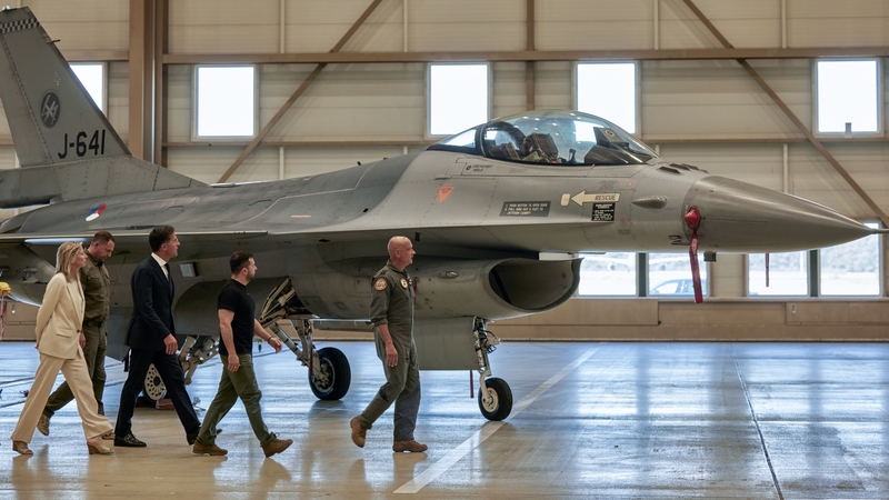 Volodymyr Zelensky and Mark Rutte during a tour of a hanger containing F-16 fighter jets at an airbase near Eindhoven