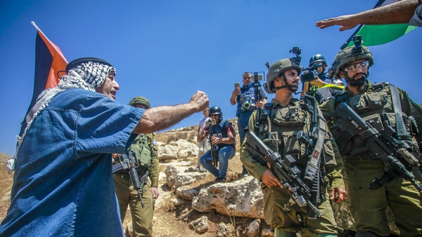 A Palestinian protester argues with Israeli soldiers, during the demonstration against Israeli settlements in the village of Beit Dajan near the West Bank city of Nablus
