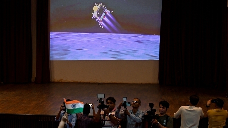 Daoine in Mumbai ag faire ar bheoshruth de thuirlingt Chandrayaan-3 ar an ngealach