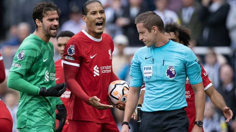 Virgil van Dijk of Liverpool argues with referee John Brooks after his red card against Newcastle