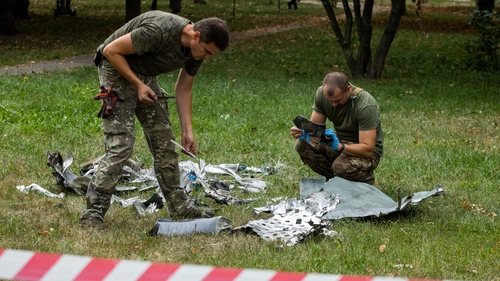Soldiers inspect the remains of missile in a Kyiv park today