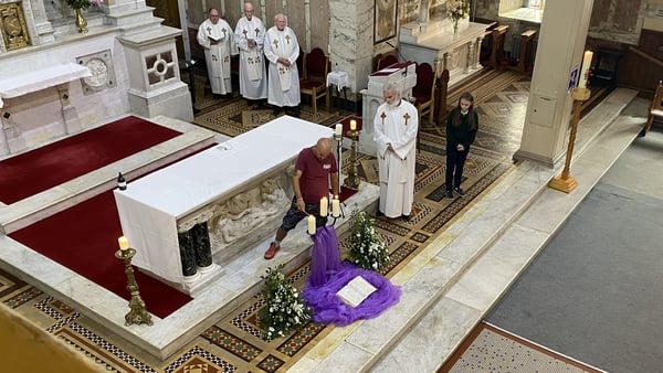 Michael O'Reilly lights three candles in memory of his brother Thomas, his sister-in-law Bridget, and their grandson Tom
