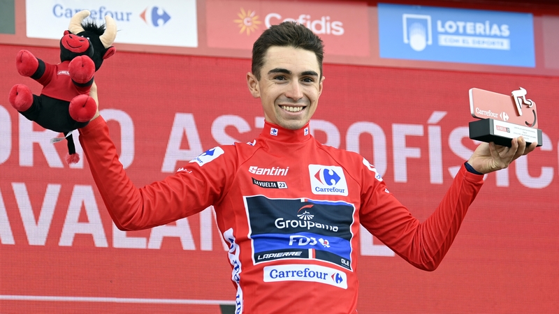 Lenny Martinez celebrates on the podium wearing the red jersey after the sixth stage