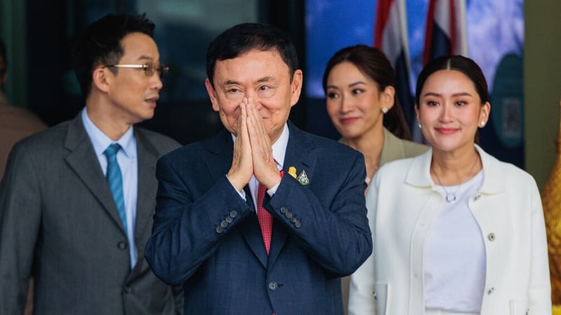 Thaksin Shinawatra (C) and his children greeting supporters as he arrived at Bangkok airport last week