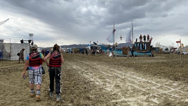 People walk through sticky mud at the Burning Man festival in Nevada