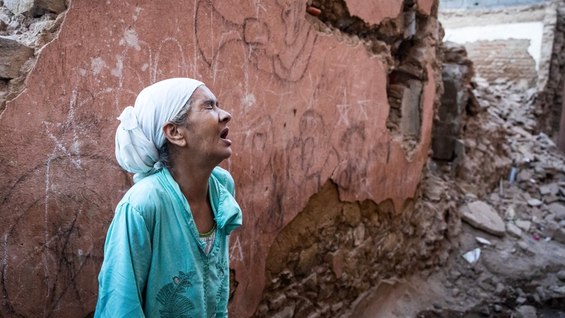 A woman reacts standing in front of her earthquake-damaged house in the old city in Marrakesh