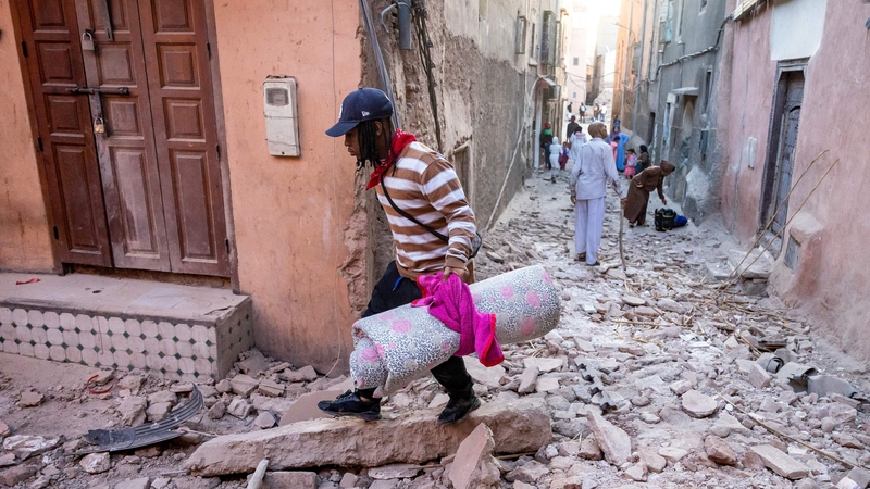 A man walks with his belongings through the rubble in an alleyway in the earthquake-damaged old city in Marrakesh