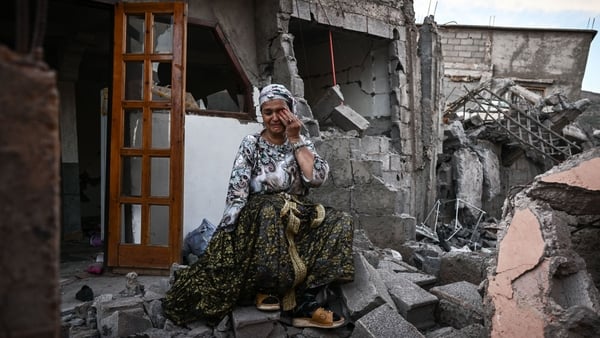 A survivor cries as she sits on the rubble of her damaged house, in the mountain village of Moulay Brahim in al-Haouz province