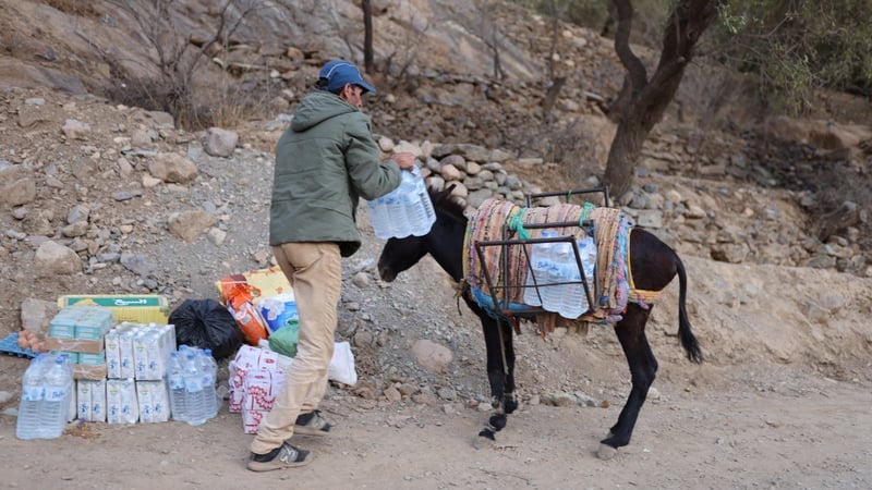 A man packs bottles of water on his donkey near Talat N'Yaaqoub