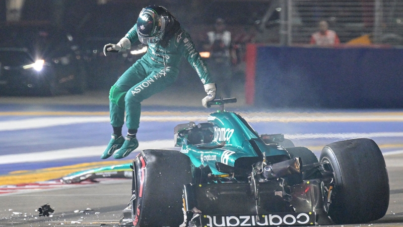 Aston Martin's Lance Stroll jumps out of his car after crashing during qualifying