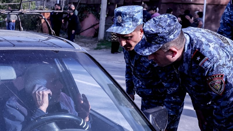 A refugee speaks to Armenian police near the border town of Kornidzor