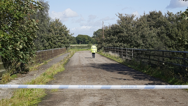 Police officers guard a bridge over the M53 motorway near the scene of the crash in Wirral, Merseyside